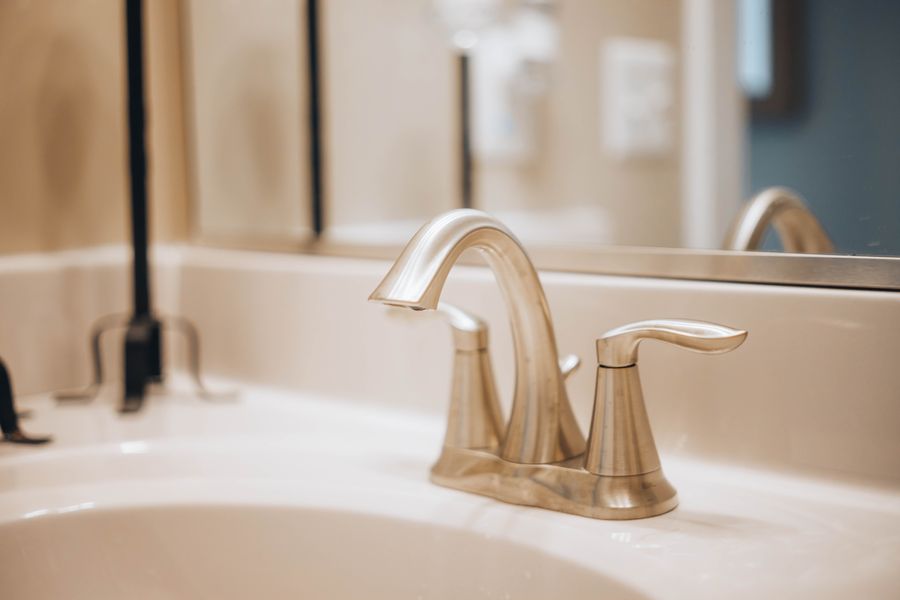 Brushed gold faucet installed on white quartz countertop — SolidStreams fixture installation